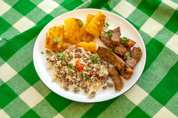 Traditional rustic tropical Brazilian dish, sun-dried beef with green beans, cassava, biquinho pepper. Creative rustic photography