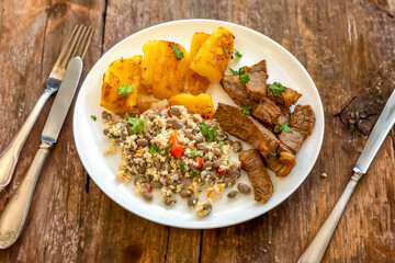 Traditional rustic tropical Brazilian dish, sun-dried beef with green beans, cassava, biquinho pepper. Creative rustic photography