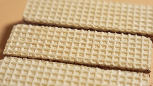 Waffles rotating on orange background. Chocolate waffles close-up on orange background.