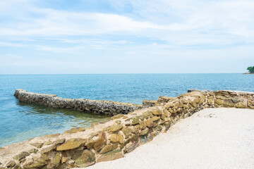 Beach sea with rocks and Soft blue ocean wave on clean sandy beach,waves splashes on rock in sea shore,Summer vibe.