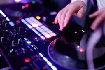 Hand eines Discjockeys am Mischpult