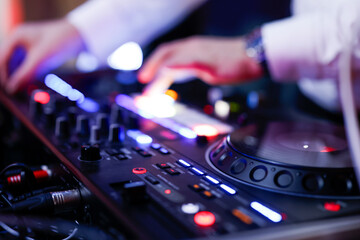 Hand eines Discjockeys am Mischpult