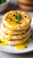 Stack of fluffy cheese pancakes drizzled with melted cheese and garnished with chives