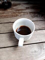 Cup of black coffee on wooden bench. Enjoying day by drink coffee in the morning.