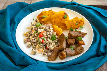 Traditional rustic tropical Brazilian dish, sun-dried beef with green beans, cassava, biquinho pepper. Creative rustic photography