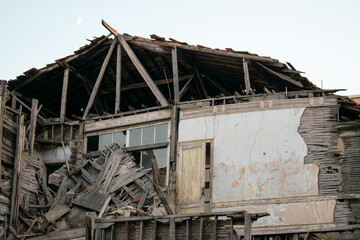 Fototapeta premium An abandoned ruined house with a wooden roof.