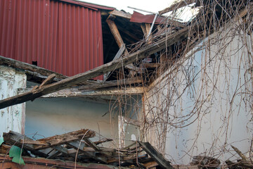 Abandoned destroyed house with collapsed roof.