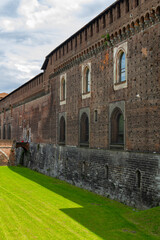 Fototapeta premium the famous historic castle castello sforzesco in Milan, Italy. At a sunny summer day with green park area 