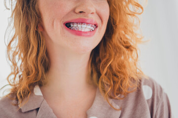 Naklejka premium Charming young woman with red hair smiling brightly in cozy pajama indoors