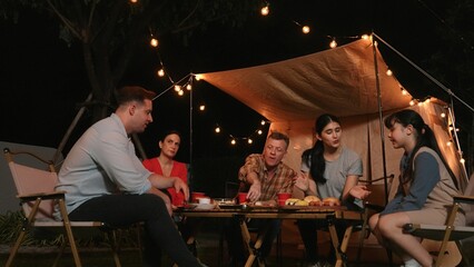 Family gather for holiday celebration in garden. Family member gather have dinner. Outdoor camping...
