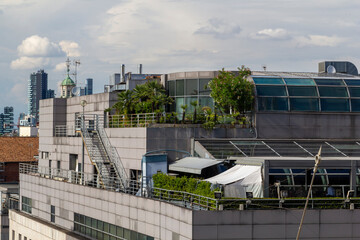 a modern rooftop luxury garden next to the historic cathedral duomo di milano in milan with the skyline in the background