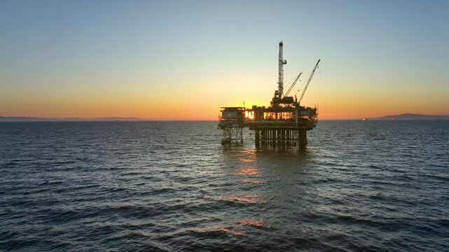 Aerial shot of an offshore oil platform at sunset