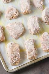 Breaded chicken breast on baking tray