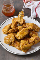 Dripping honey over baked chicken platter