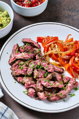 Skirt steak with peppers, corn tortillas, guacamole and pico de gallo