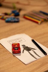 Naklejka premium Drawing of Enderman from Minecraft drawing and red Mattel Lightning McQueen toy car on a table