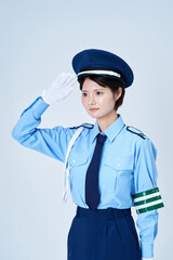 警備員の制服を着て、敬礼をする女性