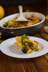 cauliflower and brussel sprouts casserole with cheese, in a plate on a wooden table