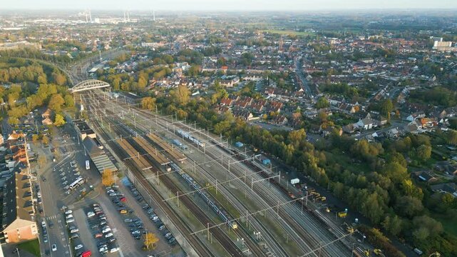 dendermonde railway station trains tracks sint gillis bij background station's role side backward aerial drone shot view footage 