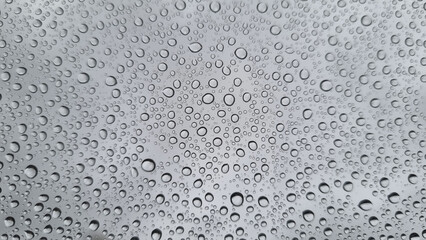 Raindrops on glass close-up. Black and white monochrome. Selective focus