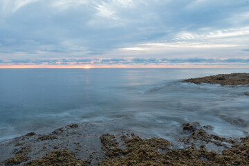 Sea water dancing on the shore under a sunrise