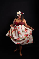 Beautiful black woman in traditional clothes and dancing Brazilian Samba. Isolated on black background.