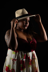 Beautiful black woman in traditional clothes and dancing Brazilian Samba in studio. Isolated on black background.