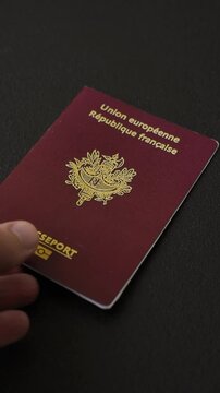 Passport of the Republic of France on a dark concrete background. Conceptual background on the theme of tourism and travel
