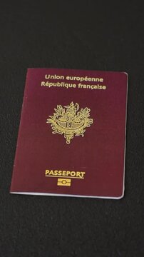 Passport of the Republic of France on a dark concrete background. Conceptual background on the theme of tourism and travel