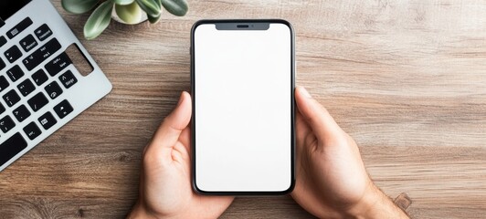 Hands Holding Smartphone with Blank Screen on Wooden Table