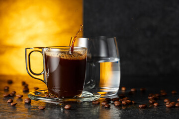 Espresso, glass of cold water, and roasted coffee beans.