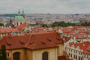 Obraz premium The skyline of Prague overlooks red rooftops of historic buildings. Discover the charm of Prague in Czech Republic - iconic landmarks, historic architecture, medieval styles and scenic views.