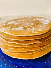 A stack of fluffy pancakes for a hearty breakfast with the whole family. A traditional light breakfast of America and European countries.