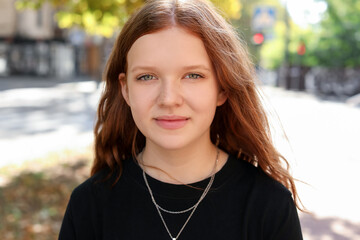 Portrait of happy teenage girl with long hair outdoors
