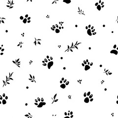 Obraz premium Black paw prints and leaves scattered on white background. Seamless pattern