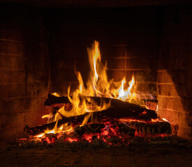 Fototapeta premium Fire flames, wood burning in fireplace. Warm home in winter, heat. Christmas holiday