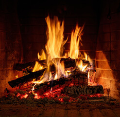 Fireplace burning, wood logs and bright flames. Warm home, heat. Christmas holiday