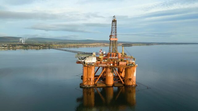 oil rig drilling platform parked estuary waiting for next operational orders significance energy production environmental aerial drone context footage 