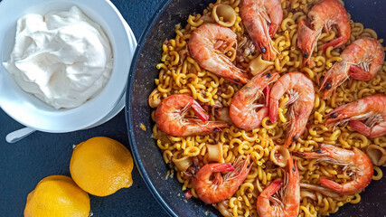 mediterranean dish of paella with fideua, shrimp and aioli