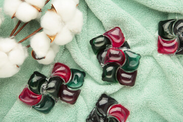 Gel capsules with laundry detergent, cotton flower on mint soft texture