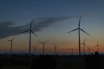 Obraz premium power generators in motion. The blades of the wind farm rotate against the sky. Windmill turbines