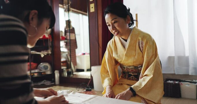 People, sewing and dressmaker for tailoring clothes, boutique and design kimono for customer in Japan. Women, small business and style fabric on board, material pattern and production process in shop