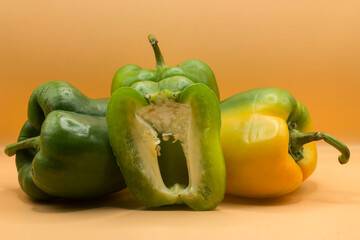 green and yellow pepper on yellow background.
