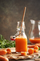 A bottle of fresh carrot juice with ecological paper straw