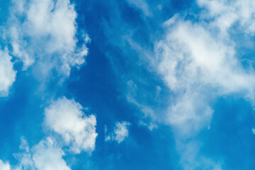 A bright blue sky with blurry white haze from the clouds. Bottom view. The state of the natural environment, the movement of air masses