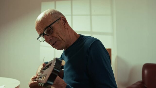Old Man Learing Guitar Tuning On Online Lesson 