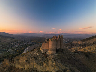 Obraz premium Fantasy fortress at sunset in the mountains of Georgia - Aerial Drone View,