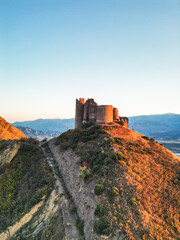 Obraz premium Fantasy breathtaking castle on top of mountain at sunset in Georgia Ksani