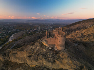 Obraz premium Fantasy breathtaking castle on top of mountain at sunset in Georgia Ksani