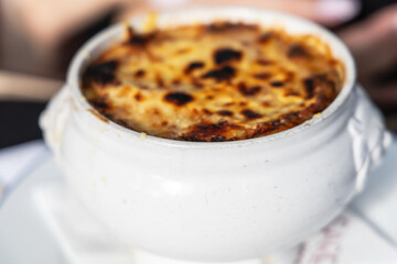 Famous french onion soup in a white pot.